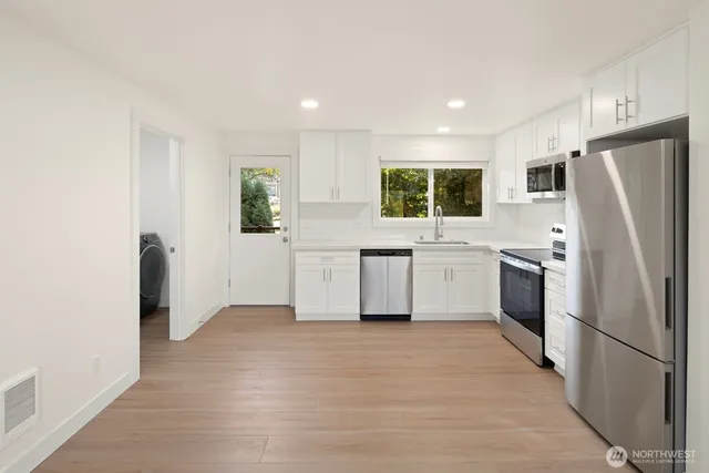 a kitchen with white cabinets and white stainless steel appliances