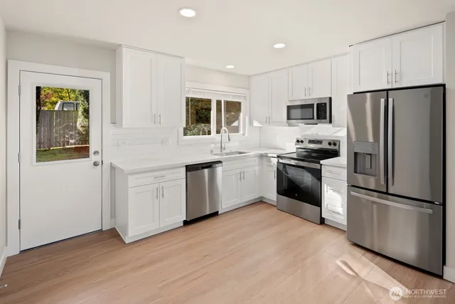 a kitchen with stainless steel appliances granite countertop a refrigerator sink and stove