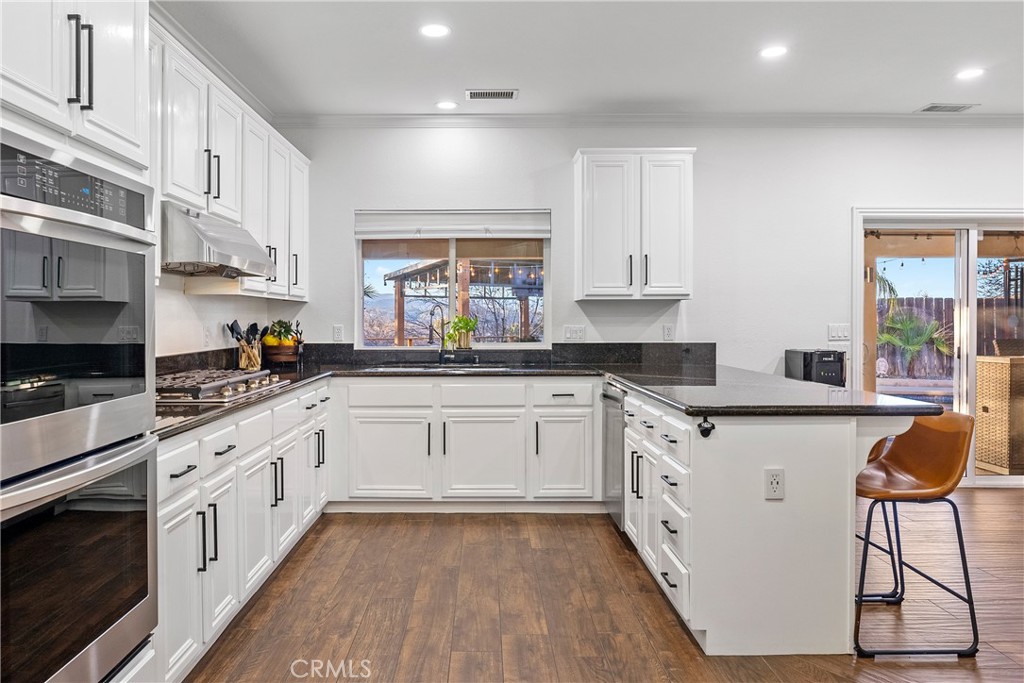 1926 Kleck Road Paso Robles, CA 93446 - Photo 9 of 29 a white kitchen with stainless steel appliances granite countertop a stove a sink and white cabinets