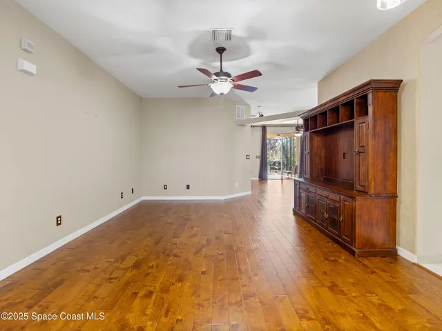 a view of an empty room with a ceiling fan