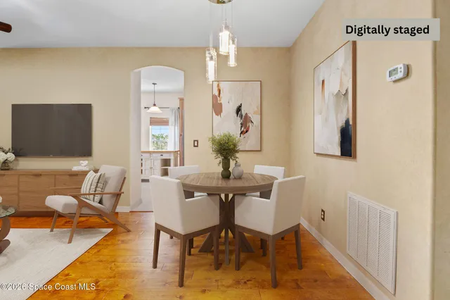 a dining room with furniture potted plants and wooden floor