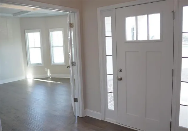 an empty room with wooden floor and windows