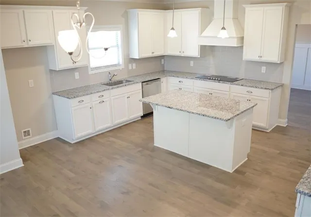 a kitchen with granite countertop white cabinets and white appliances