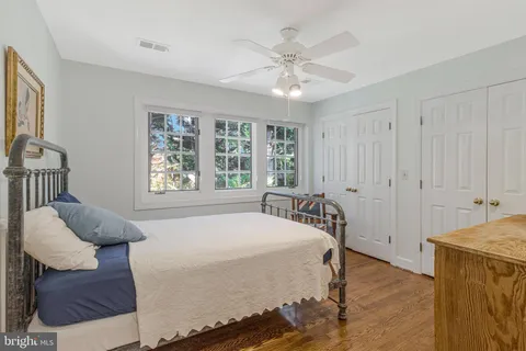 a bedroom with a bed and dresser with the outer view
