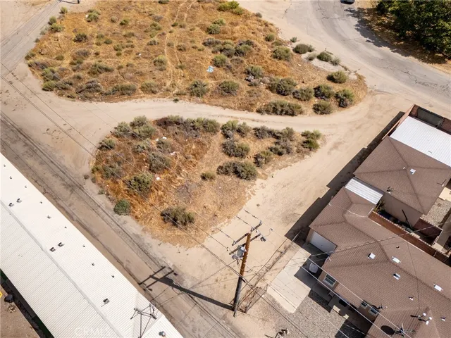 an aerial view of a house a yard and mountain view in back