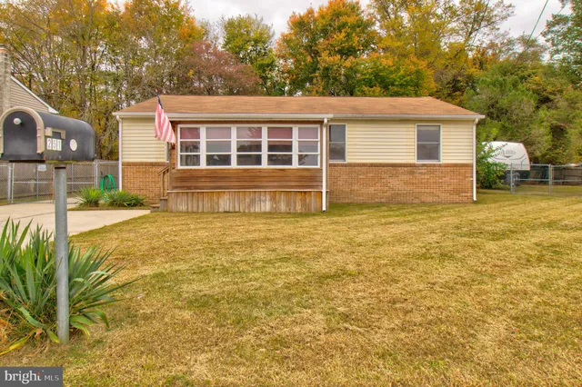 a view of a house with a small yard and a large tree