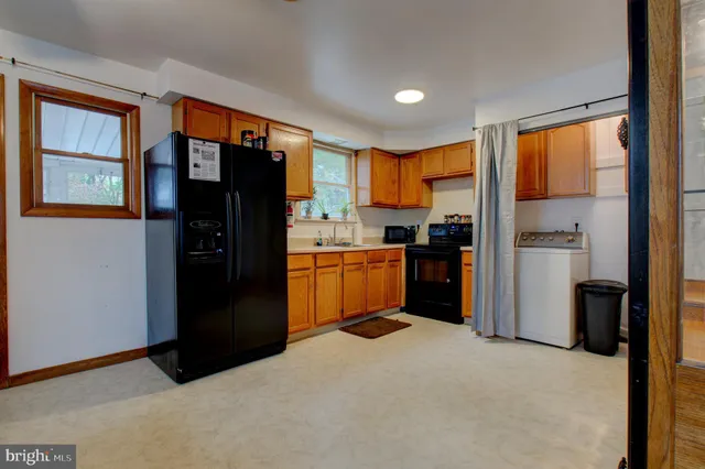 a kitchen with stainless steel appliances granite countertop sink refrigerator and window