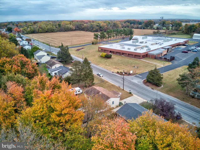 an aerial view of a house a yard and mountain view in back