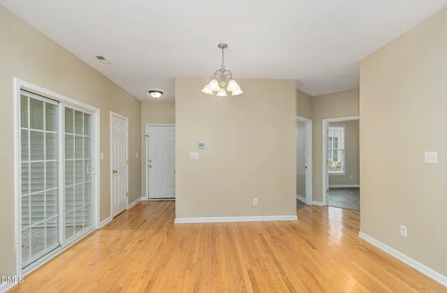 a view of a room with wooden floor and a ceiling fan