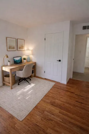 a view of a workspace with furniture and a window
