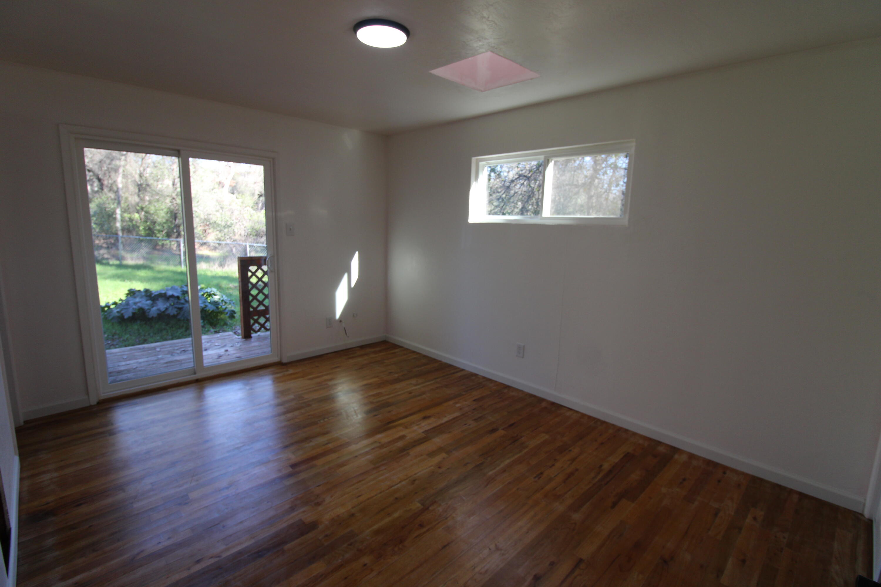 3170 Quartz Hill Road Redding, CA 96003 - Photo 37 of 68 an empty room with wooden floor and windows