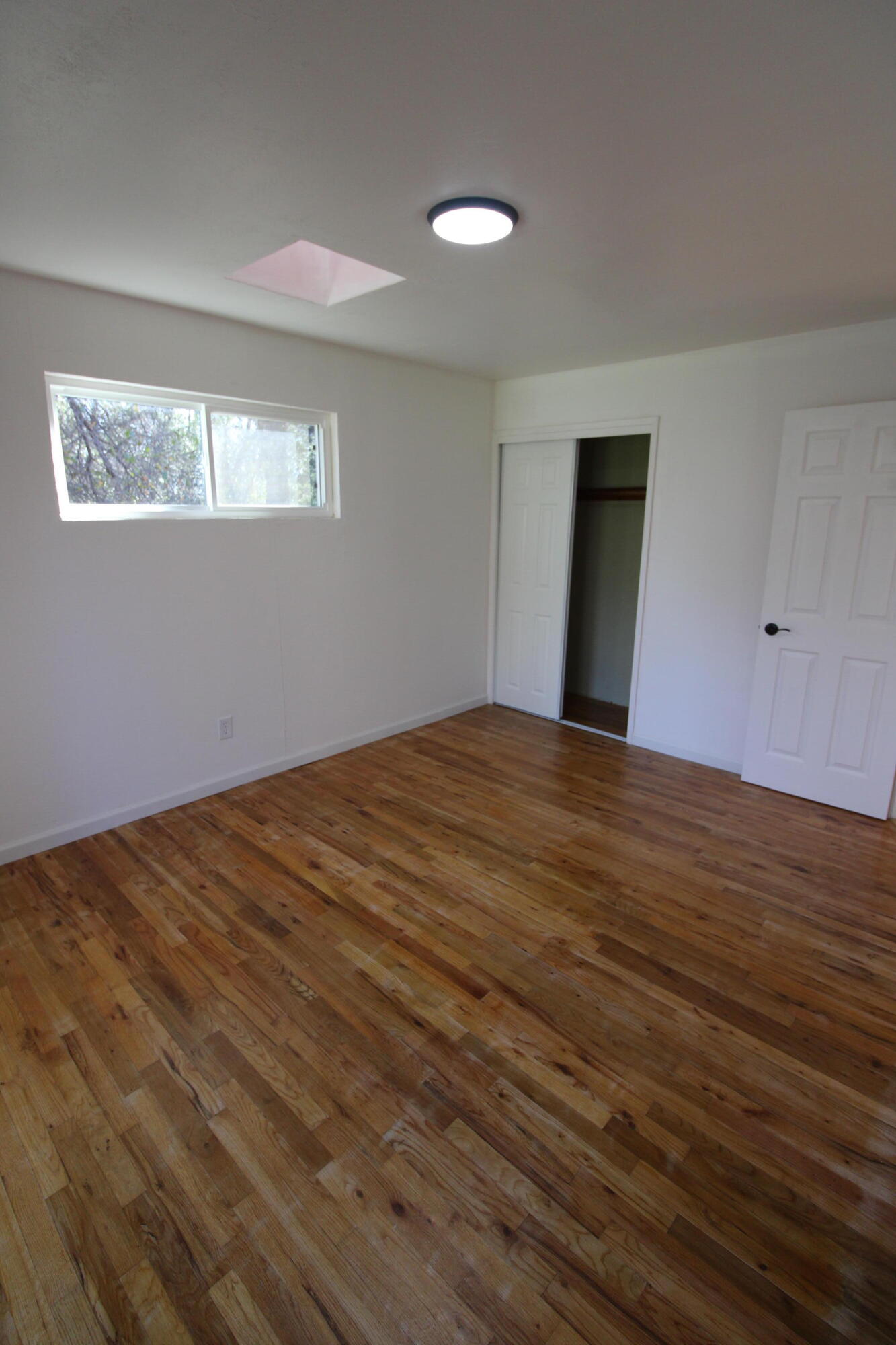 3170 Quartz Hill Road Redding, CA 96003 - Photo 38 of 68 a view of an empty room with wooden floor and a window