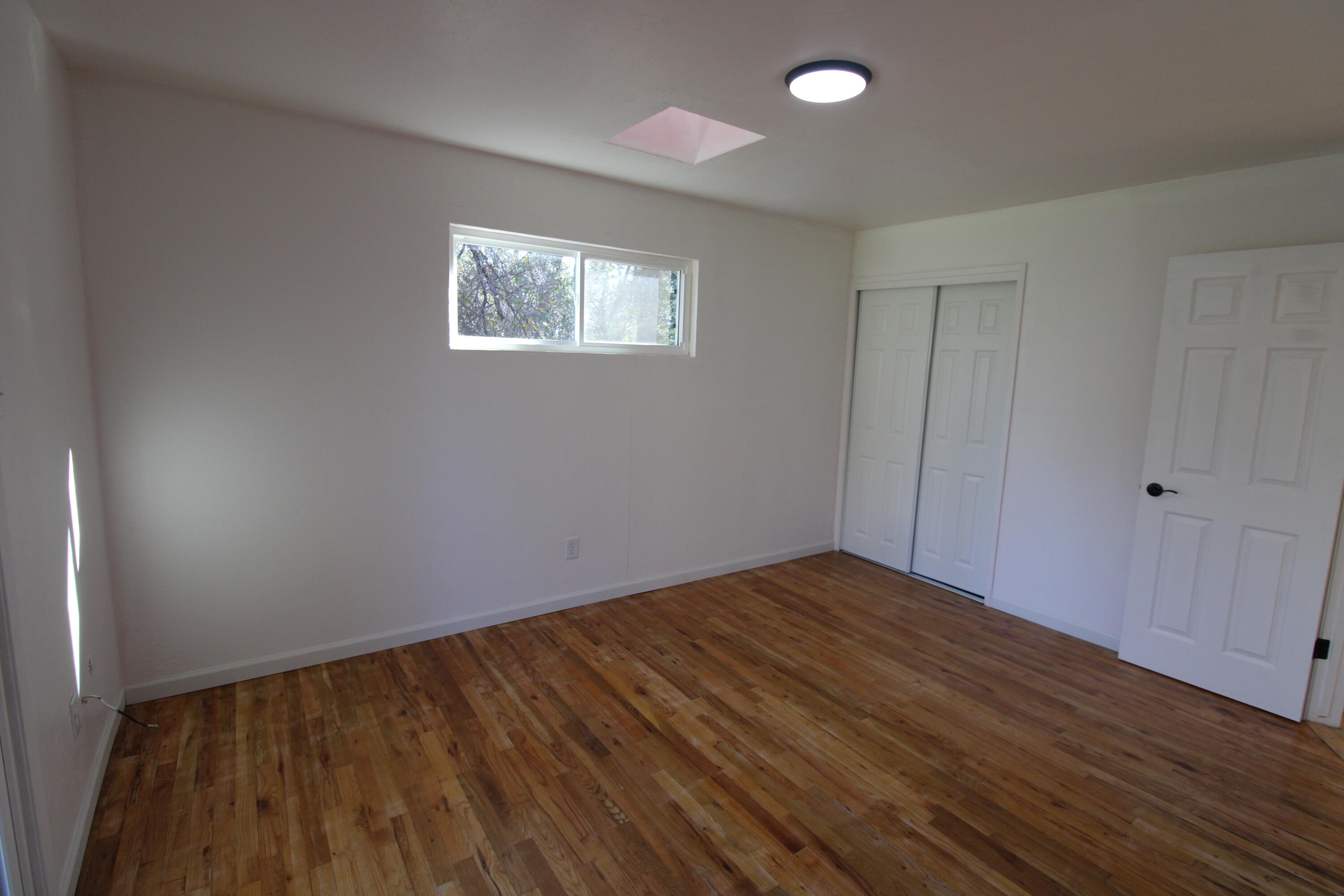 3170 Quartz Hill Road Redding, CA 96003 - Photo 39 of 68 a view of an empty room with wooden floor and a window
