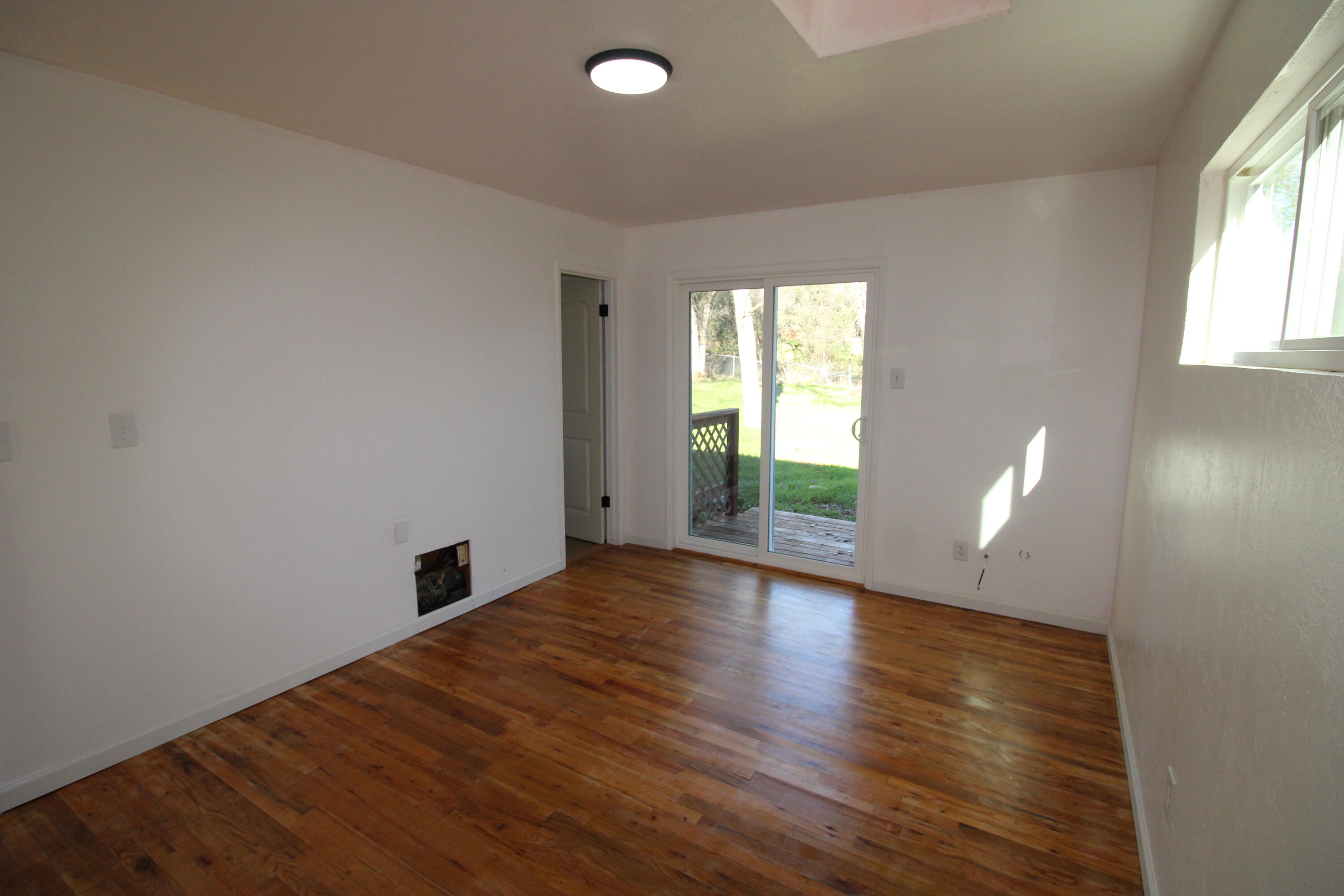 3170 Quartz Hill Road Redding, CA 96003 - Photo 40 of 68 an empty room with wooden floor and windows