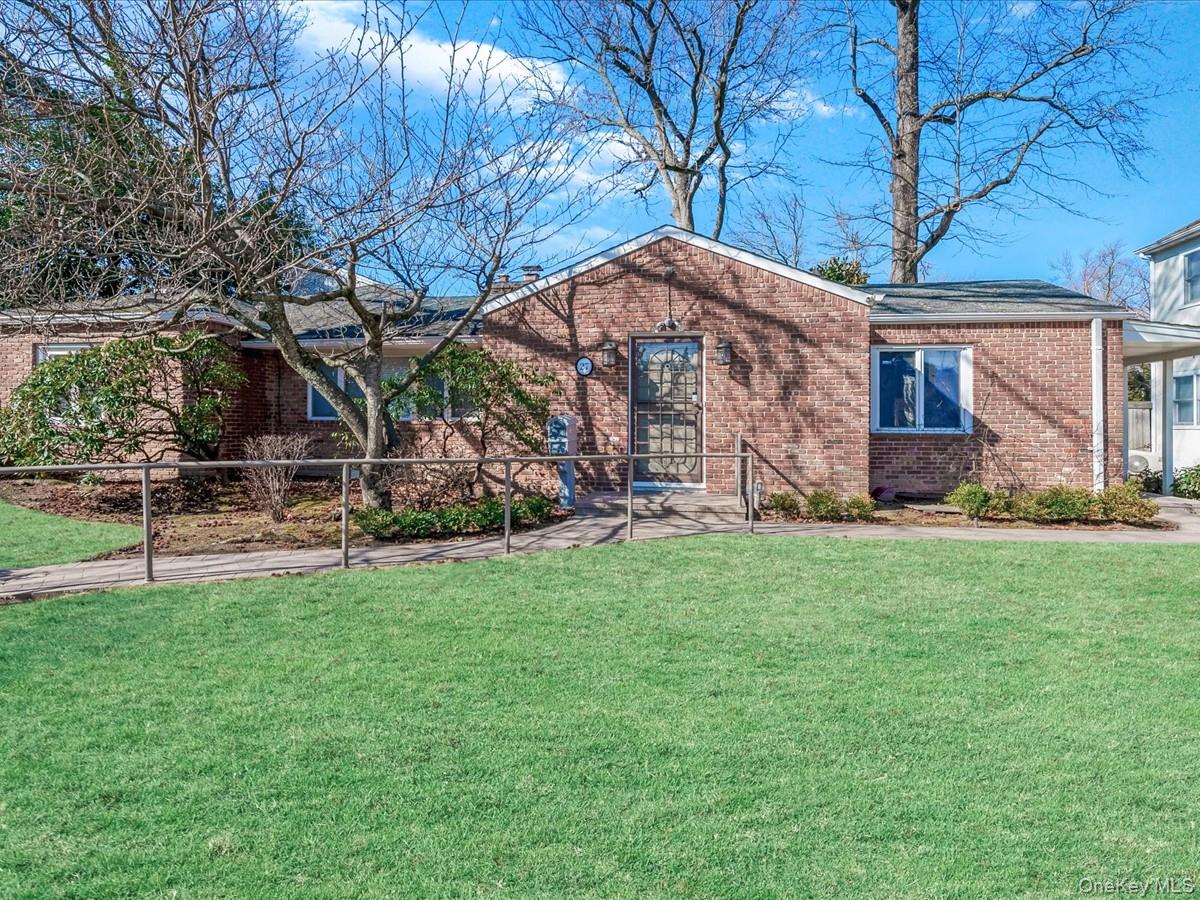 a view of a house with backyard and a tree