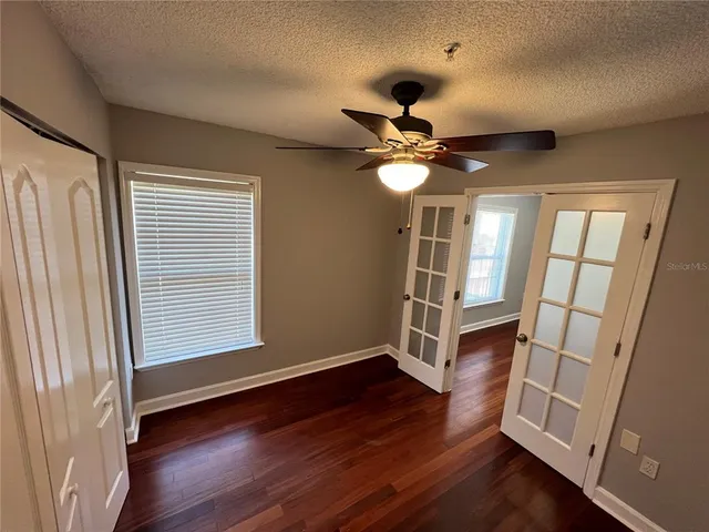 an empty room with wooden floor and window