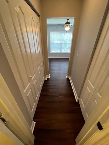 a view of a hallway with wooden floor and staircase