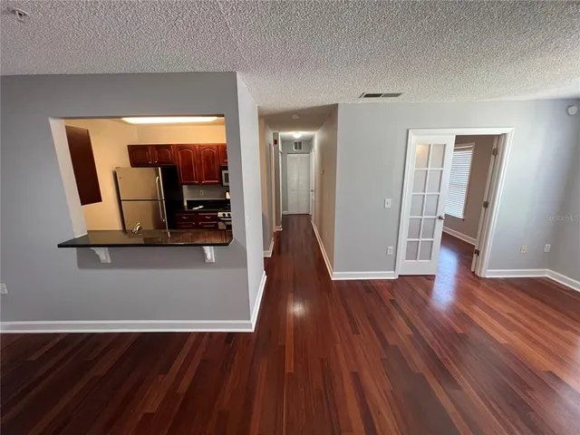 a view of a hallway with wooden floor and furniture
