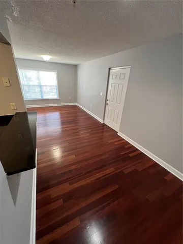 a view of room with window and wooden floor