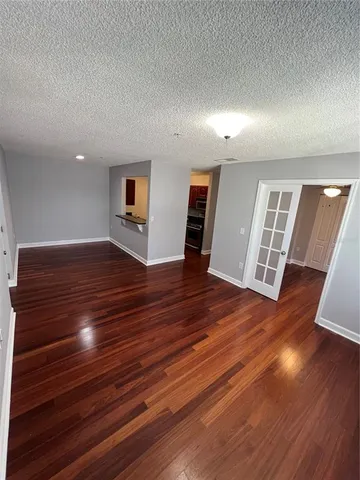 a view of empty room with wooden floor