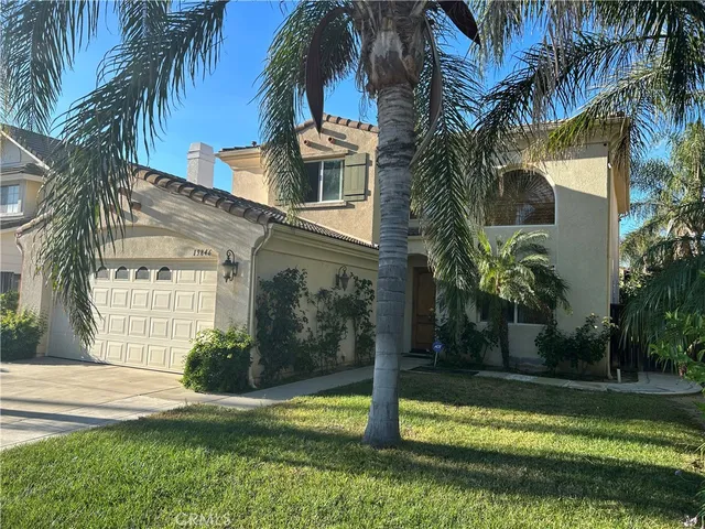 a view of a house with a yard and palm trees