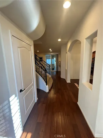 a view of a hallway with wooden floor and stairs