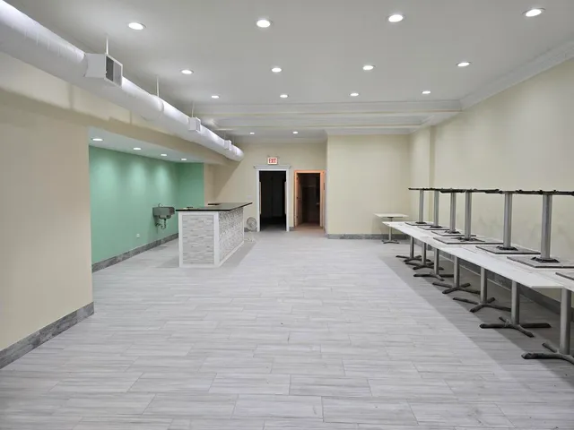 a view of an empty room with stairs and a workspace
