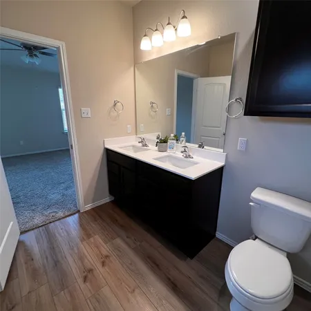 a bathroom with a sink vanity mirror and toilet