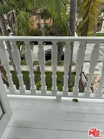a view of a kitchen with wooden floor electronic appliances and cabinets