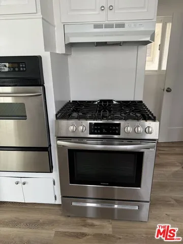 a kitchen with granite countertop white cabinets sink and window