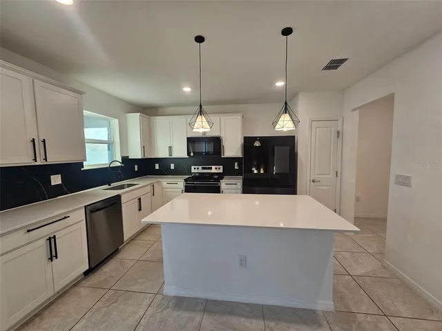 a kitchen with a sink a counter top space cabinets and stainless steel appliances