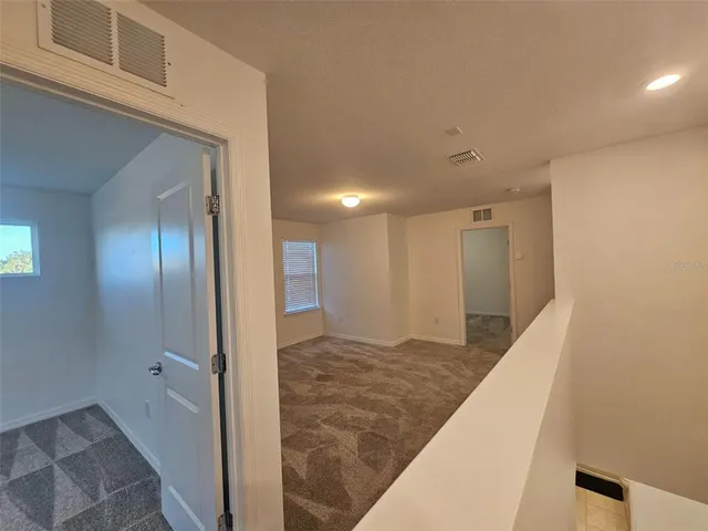 a view of a hallway with entryway and stairs