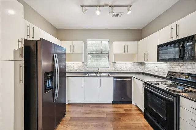 a kitchen with stainless steel appliances granite countertop a refrigerator stove and microwave