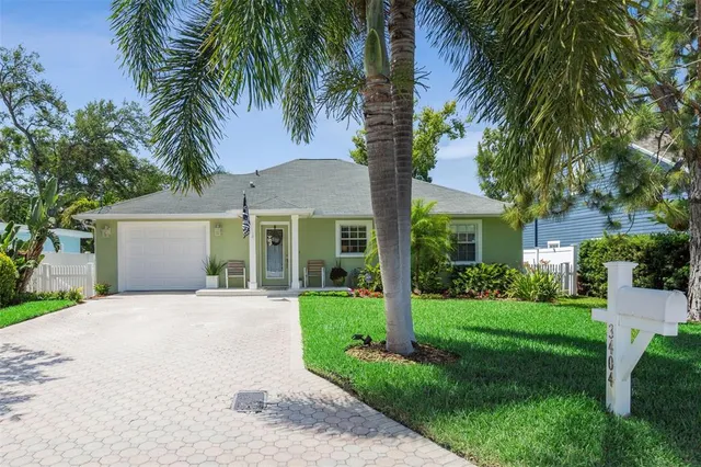 a front view of a house with a garden and trees