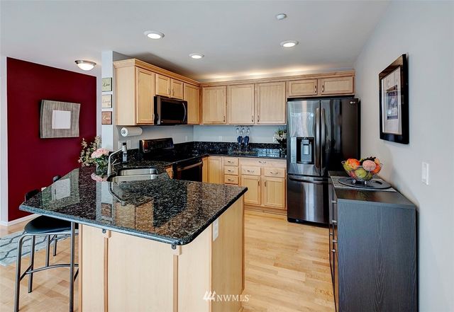 a kitchen with stainless steel appliances granite countertop a stove refrigerator sink and cabinets