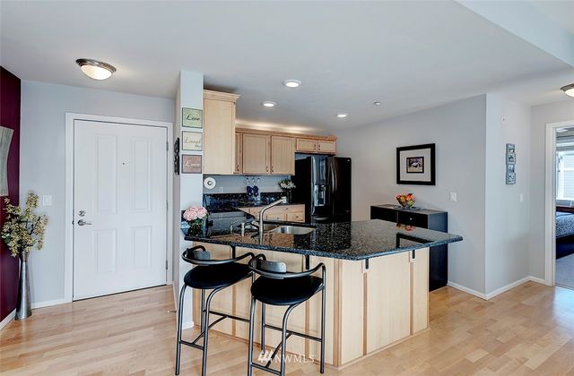 a kitchen with a refrigerator and a stove top oven