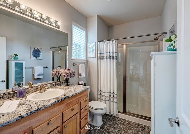 a bathroom with a granite countertop sink toilet and shower