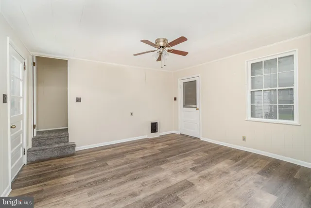 a view of a big room with wooden floor and windows in a room