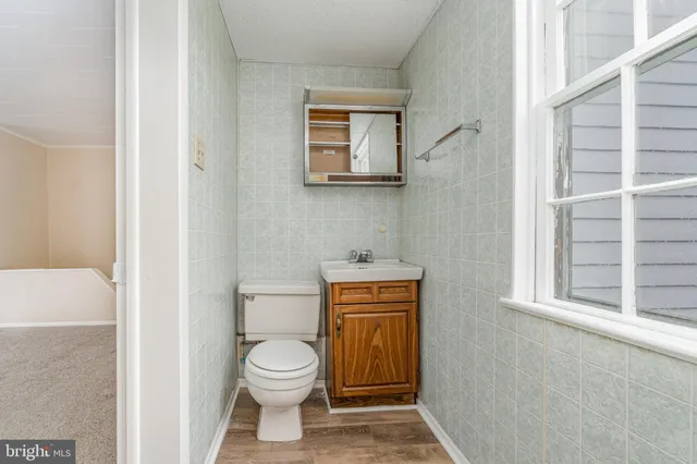 a bathroom with a toilet a sink a vanity and mirror