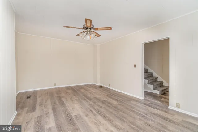 a view of room with hardwood floor and ceiling fan