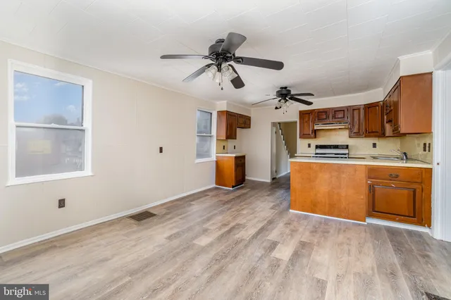 a kitchen with stainless steel appliances granite countertop a sink cabinets and wooden floor