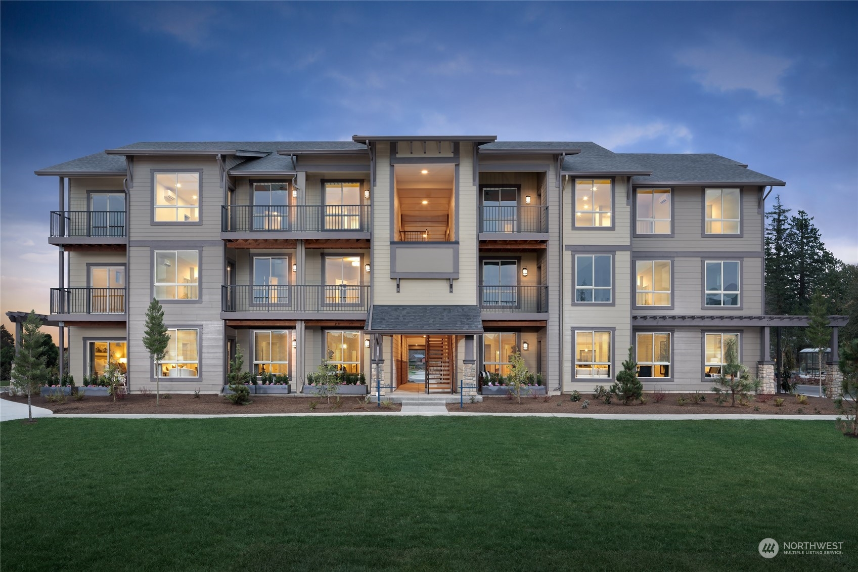 a front view of a residential apartment building with a yard