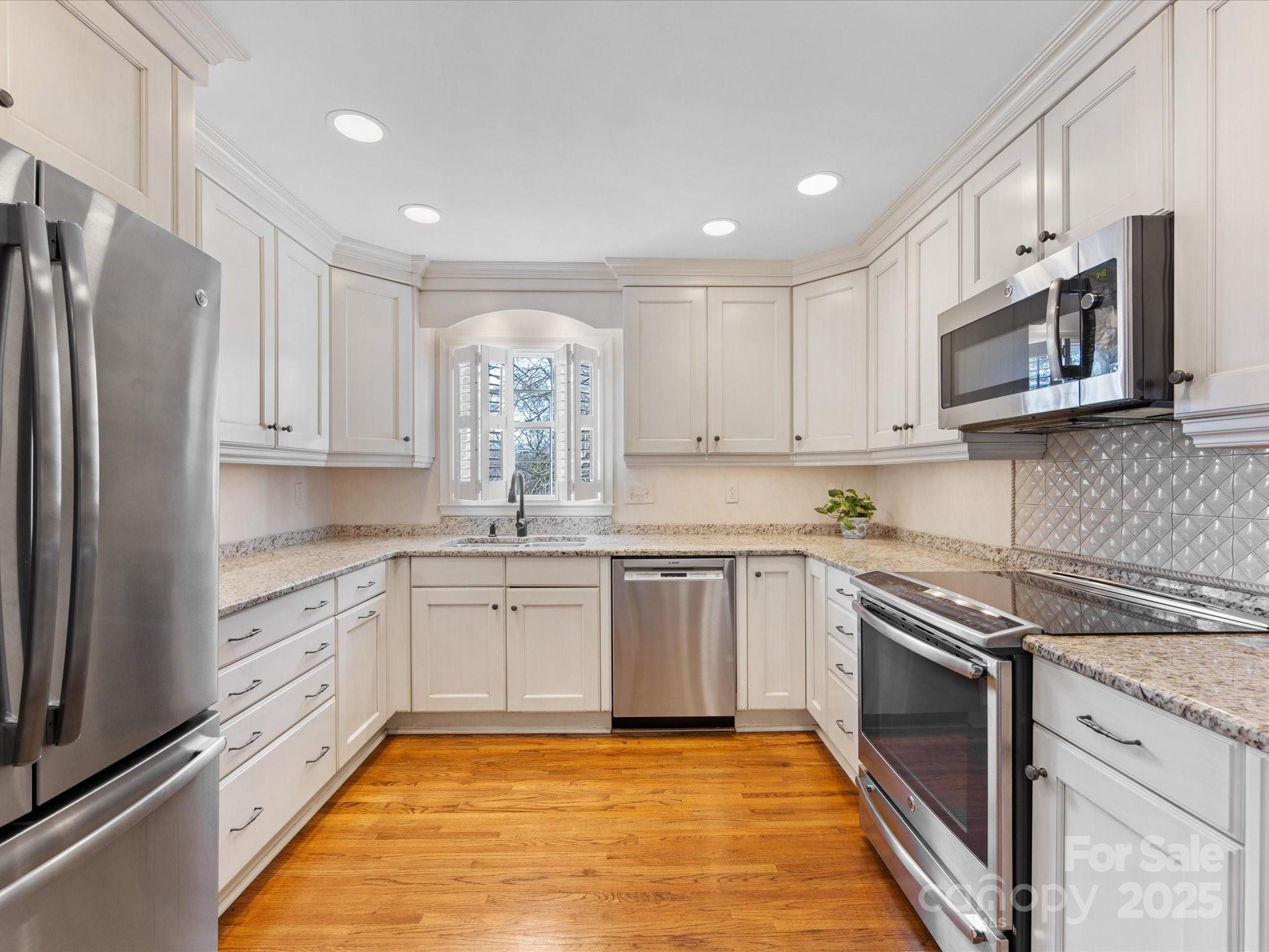 555 Manning Drive, Unit 7 Charlotte, NC 28209 - Photo 13 of 45 a kitchen with stainless steel appliances granite countertop a stove top oven a sink and dishwasher a refrigerator with white cabinets