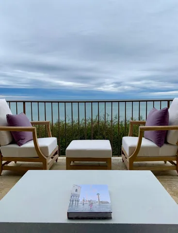a balcony with chairs and a table