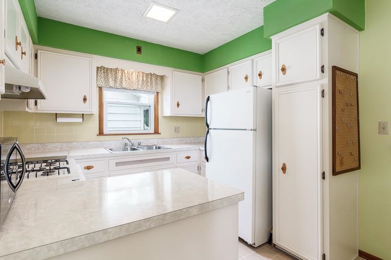 4702 Mohawk Road Rockford, IL 61107 - Photo 13 of 41 a white refrigerator freezer sitting inside of a kitchen