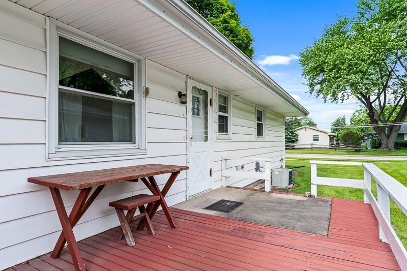 4702 Mohawk Road Rockford, IL 61107 - Photo 31 of 41 a view of a deck with table and chairs with wooden floor and fence