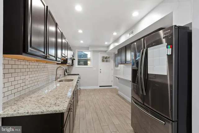 a kitchen with granite countertop stainless steel appliances counter space and a refrigerator