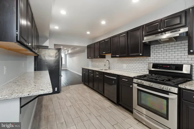 a kitchen with kitchen island granite countertop wooden cabinets and a stove