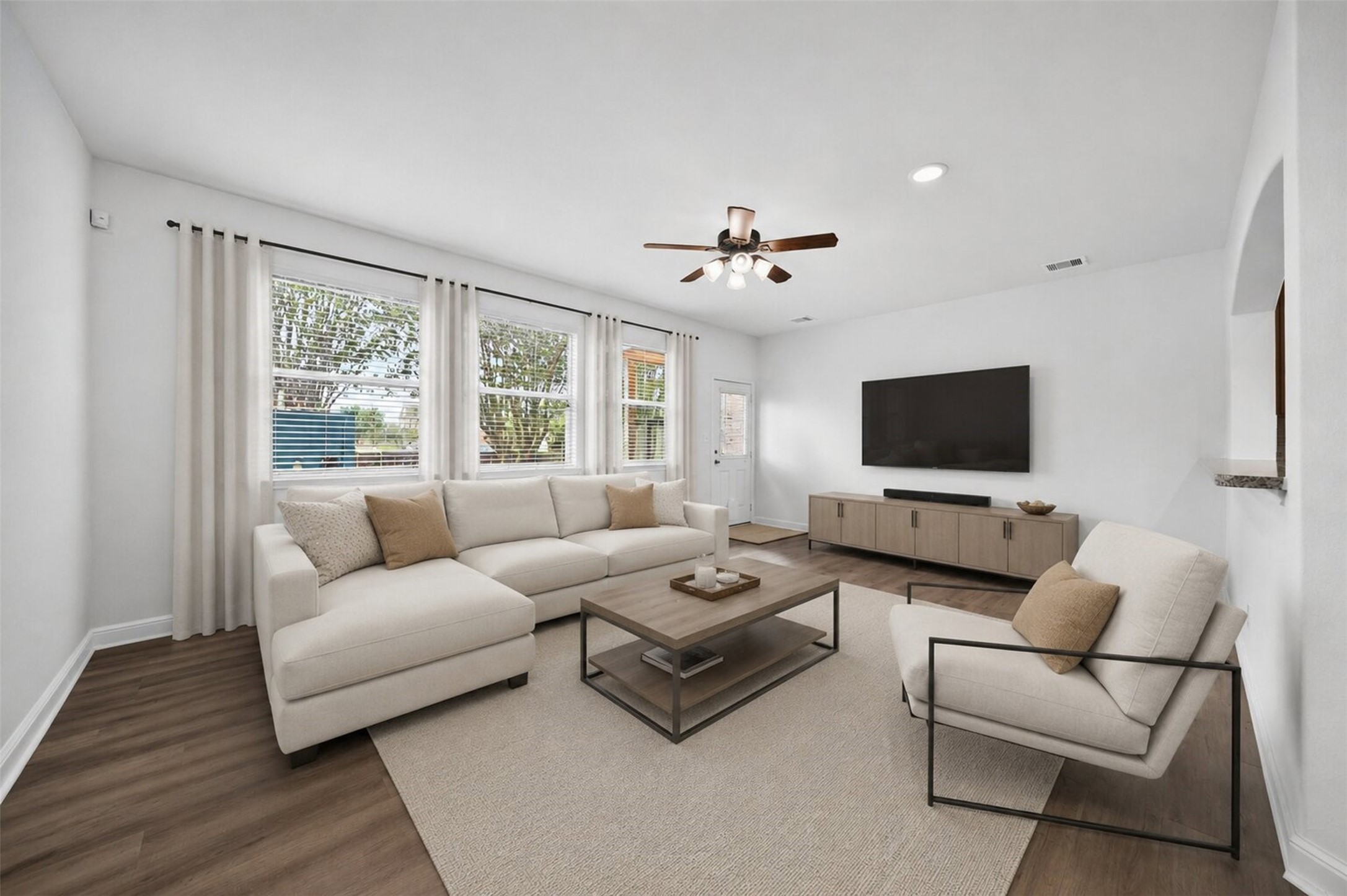 10510 Day Trail Lane Spring, TX 77379 - Photo 10 of 28 Virtually staged living room. An inviting space with wall of three oversized windows, rich wood-look flooring, and a crisp neutral color palette that makes the room feel incredibly spacious and move-in ready.