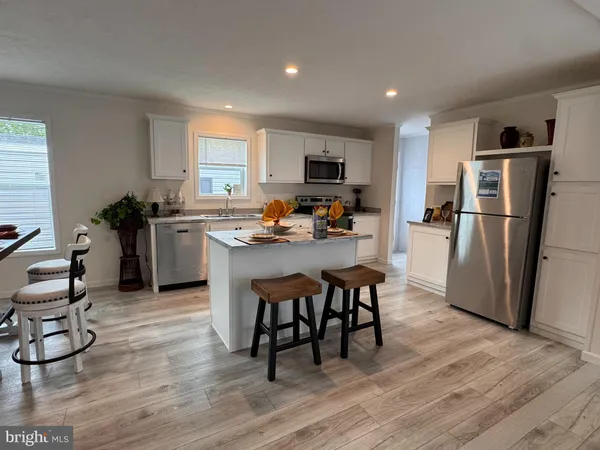 a kitchen with a dining table chairs refrigerator and cabinets